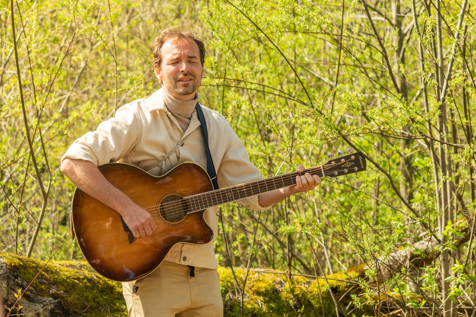 Mann mit Gitarre im Wald