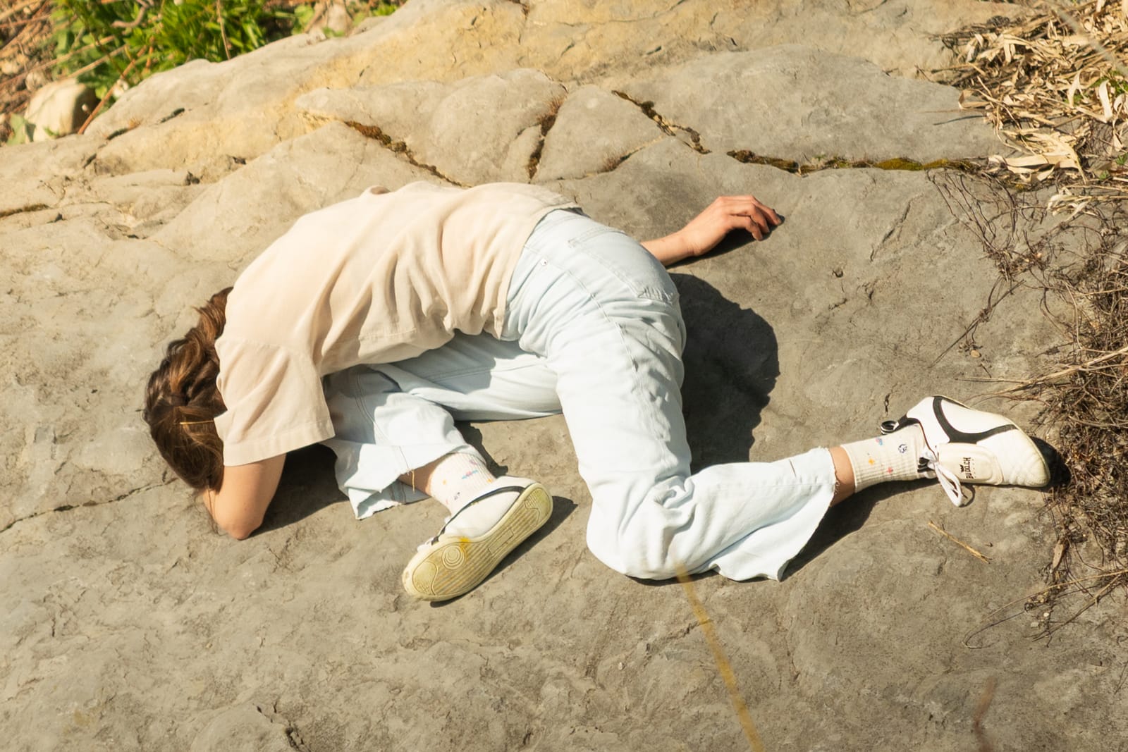 Person liegt auf einem Felsen
