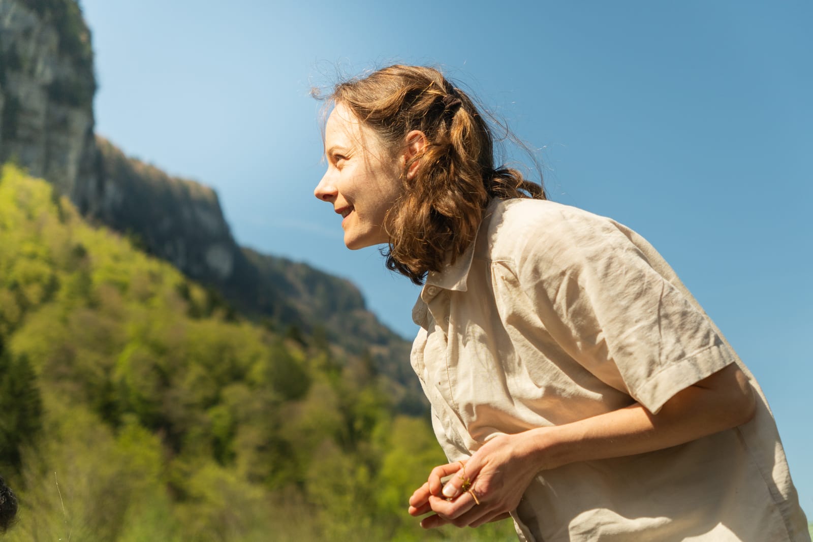 Lachende Person im Profil mit Berg im Hintergrund