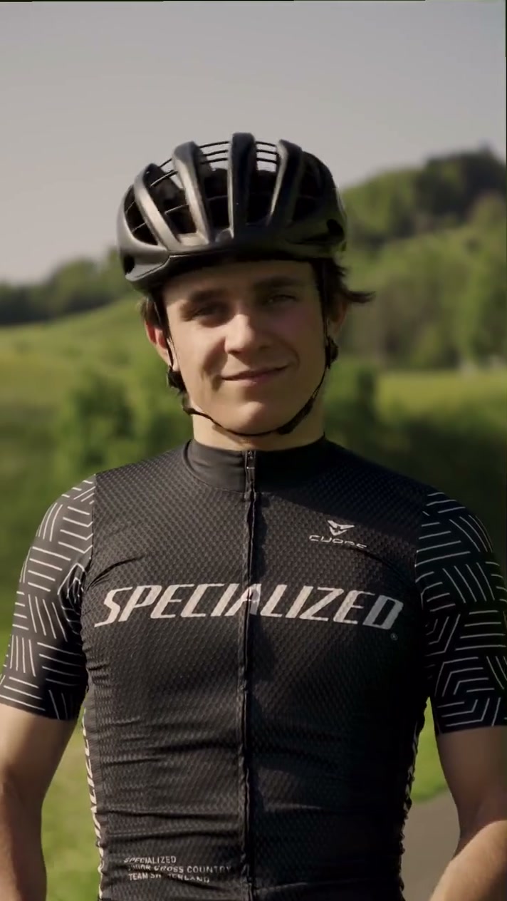 Athlet Gian Sidler im Specialized-Trikot mit Helm schaut lächelnd in die Kamera